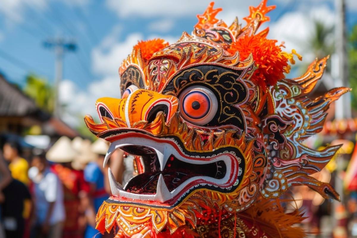 Vibrant dragon mask adorned with intricate patterns and bright colors, set against a festive background with blurred people and greenery.